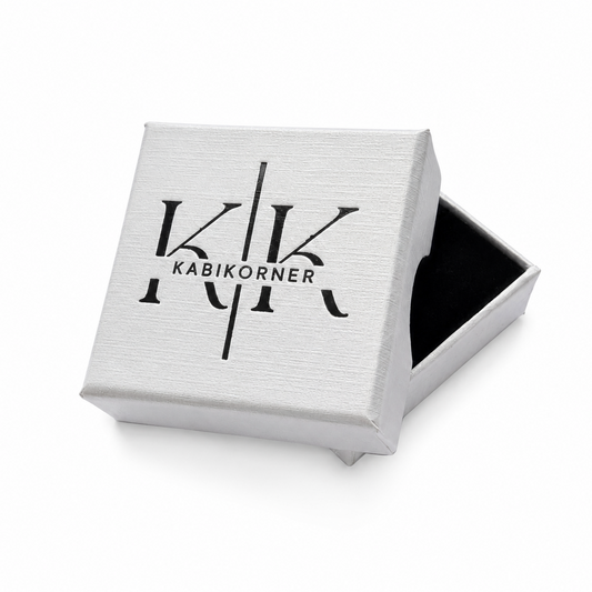 A square white presentation box, shown open with a black interior. The lid features a black printed logo reading 'KABIKORNER'.