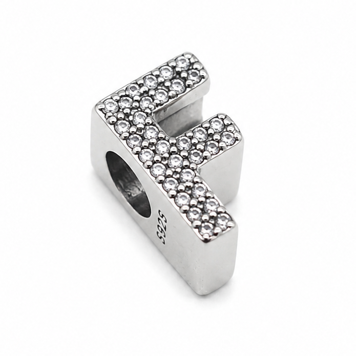 A sterling silver letter 'F' initial charm embellished with small clear pavé stones and hallmark S925 visible, shown on a plain white background.
