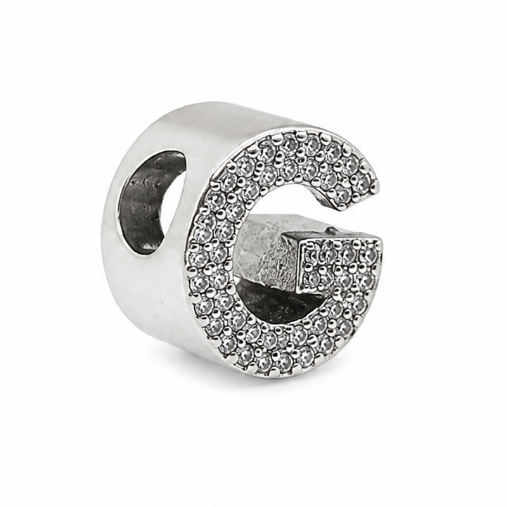 A sterling silver letter 'G' charm bead embellished with clear pavé stones, shown on a plain white background.