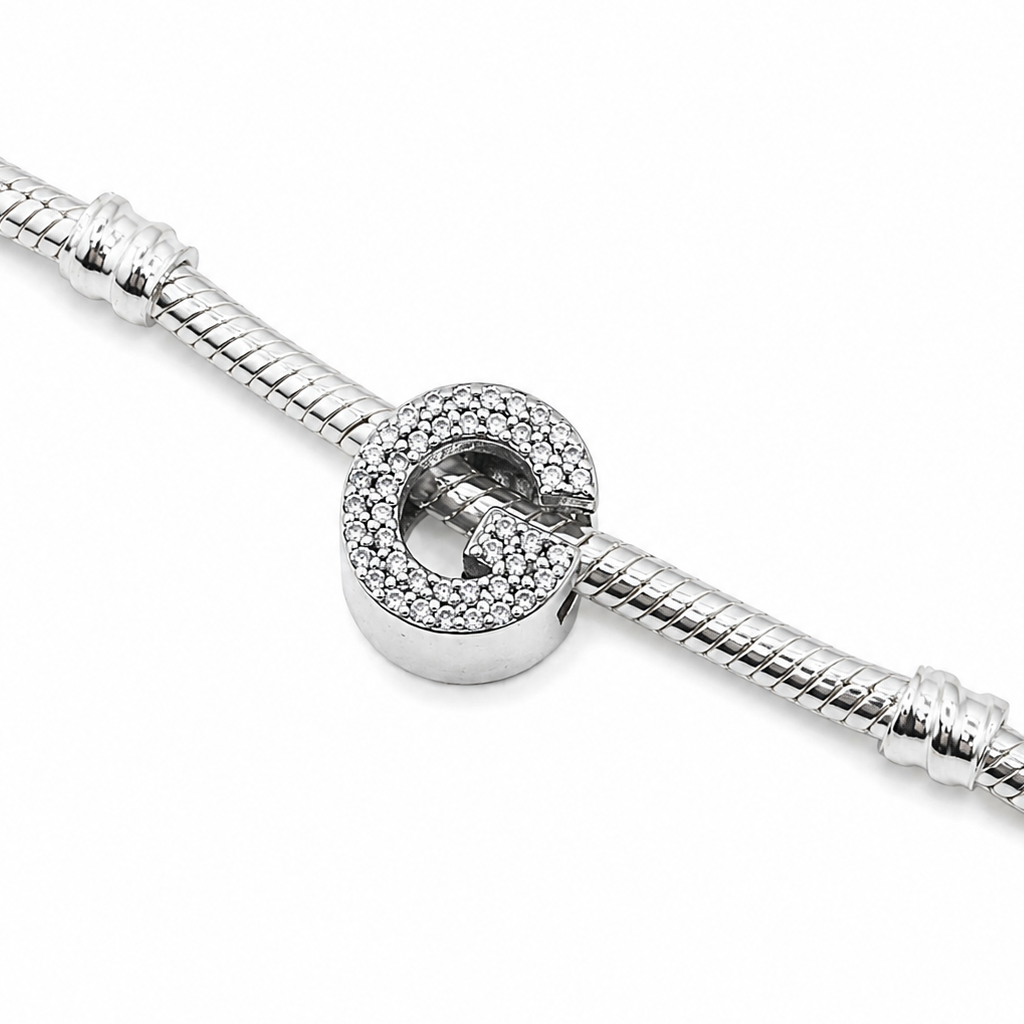 A silver snake chain bracelet featuring a Sterling silver letter 'G' initial charm with cubic zirconia stones covering the front of the letter, shown on a plain white background.