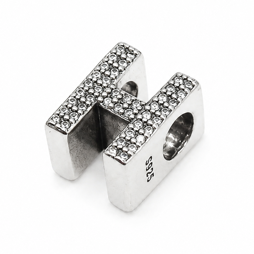 A sterling silver letter 'H' charm bead embellished with small clear pavé stones on the top surfaces, shown on a plain white background.