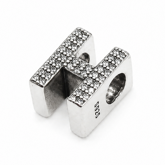 A sterling silver letter 'H' charm bead embellished with small clear pavé stones on the top surfaces, shown on a plain white background.