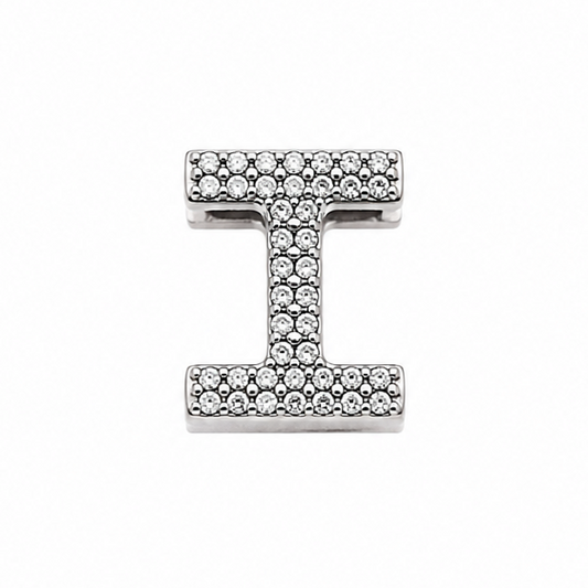 A sterling silver letter 'I' initial charm paved with small clear stones, centered on a plain white background.