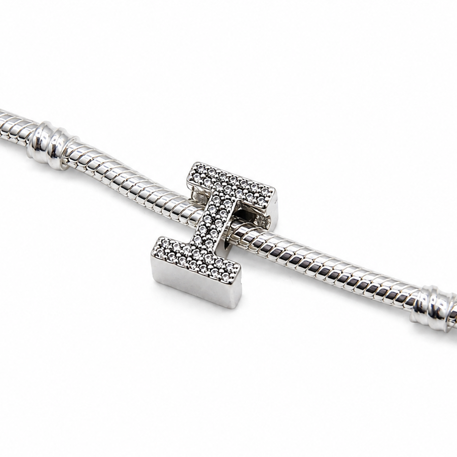 A sterling silver initial 'I' charm bead with pavé-set clear stones, shown on a silver snake chain against a plain white background.