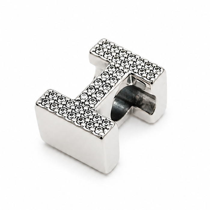 A sterling silver letter 'I' initial charm paved with small clear stones, centered on a plain white background.