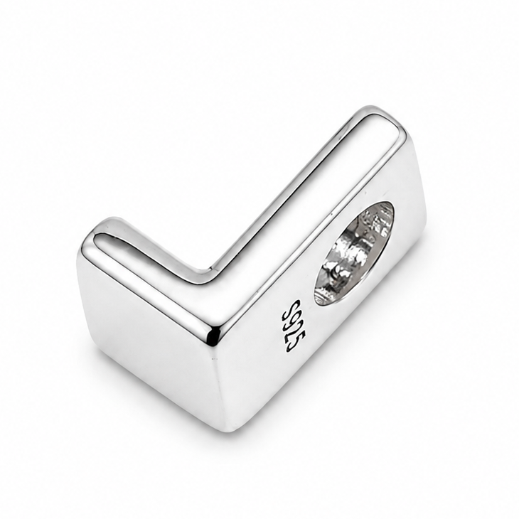 A sterling silver letter 'L' charm photographed from the back showing polished silver with the letter back-to-front. on a plain white background.