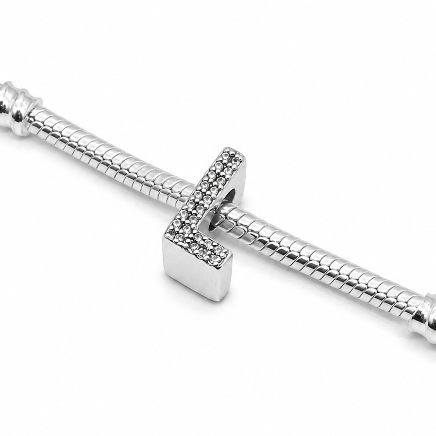 A silver snake chain bracelet featuring a sterling silver letter 'L' charm bead embellished with pavé-set clear crystals on a plain white background.