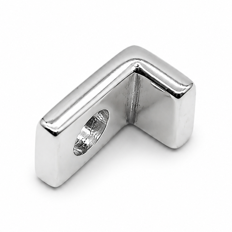 A sterling silver letter 'L' charm photographed from the back showing polished silver with the letter back-to-front. on a plain white background.