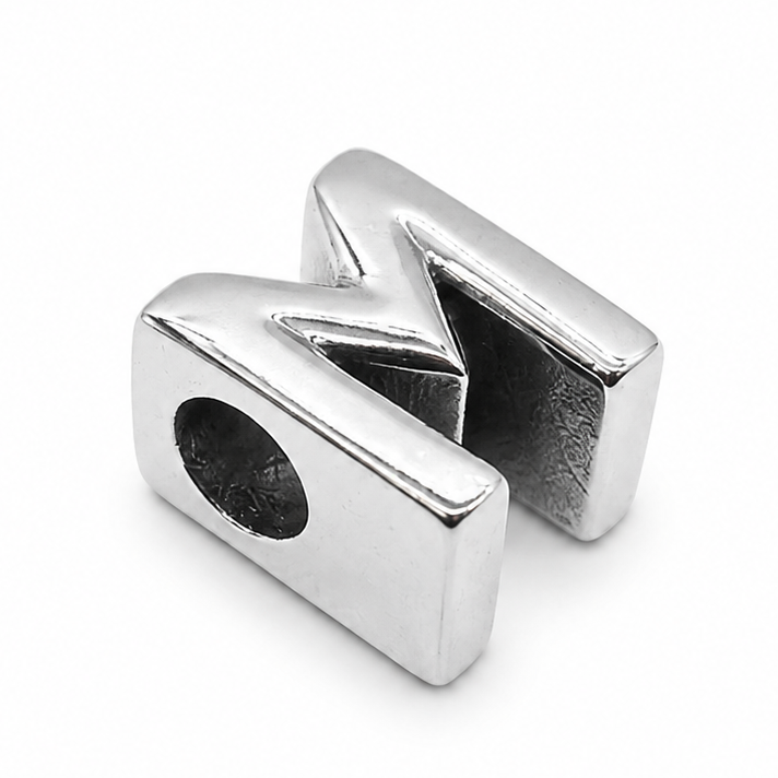 A polished silver metal letter 'M' initial charm bead with a circular hole on one end, shown on a clean white background.