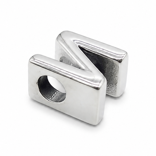 A polished silver metal charm shaped like the letter 'N', featuring a smooth reflective finish and a central hole, set against a plain white background.